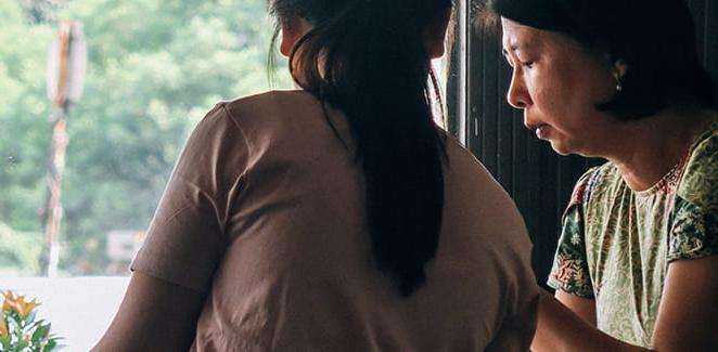 Mother and daughter working together in front of window