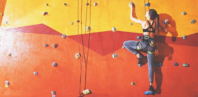 Person climbing up an indoor climbing wall