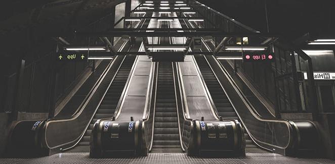 Looking up three empty escalators from the bottom of a subway.